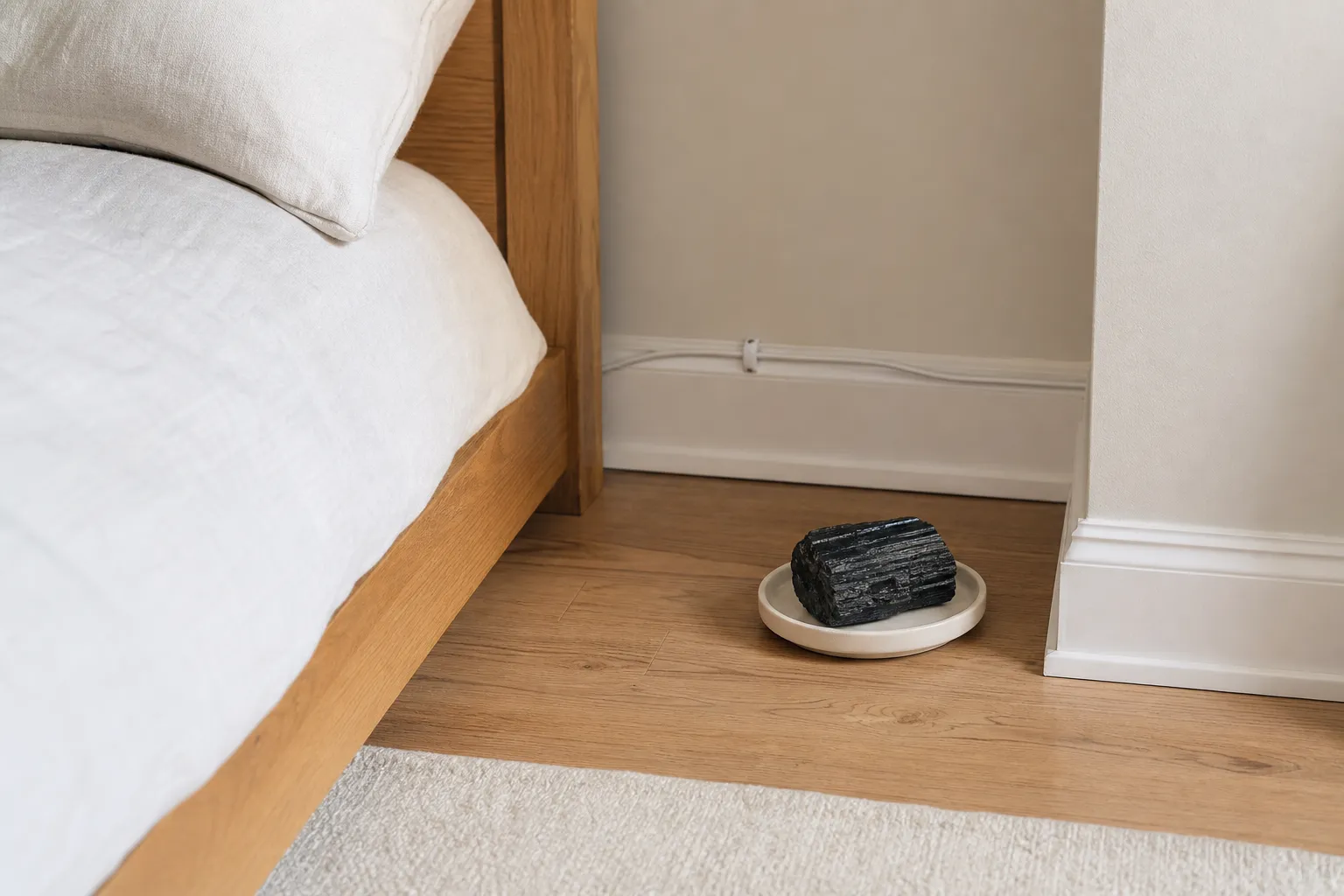 A bedroom corner with black tourmaline kept clear of cords, bedding, and walking paths