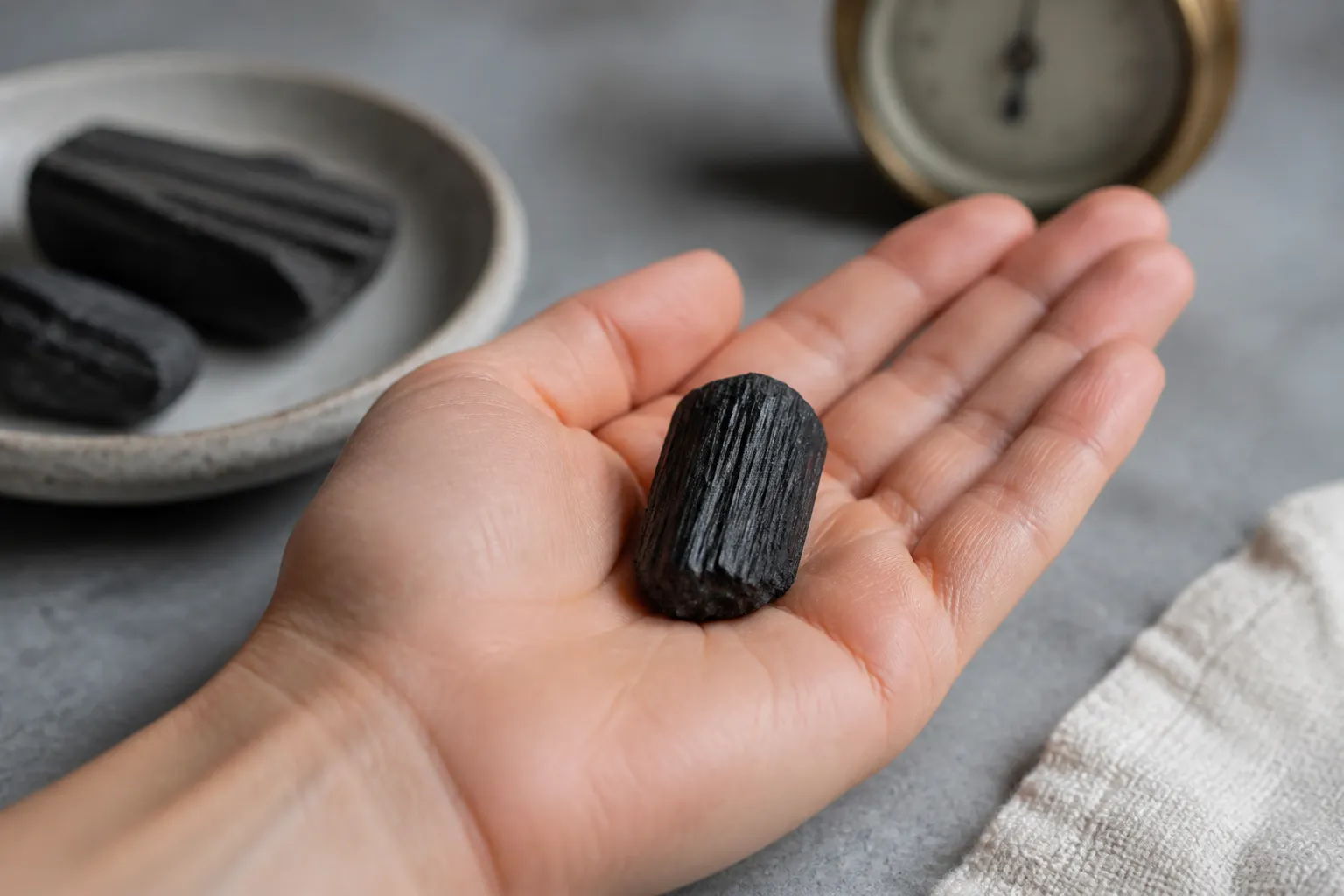 A cool black tourmaline stone warming in a hand to show temperature change as the realistic pyroelectric trigger