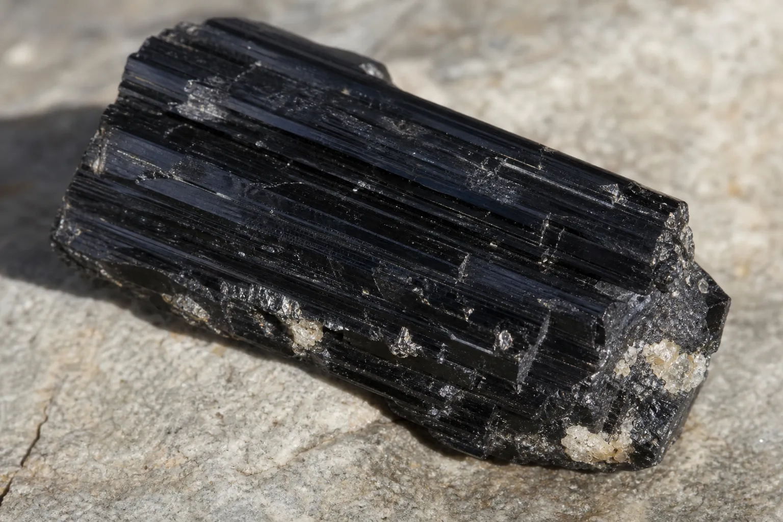 Raw striated schorl showing lengthwise grooves, broken terminations, and uneven surface texture
