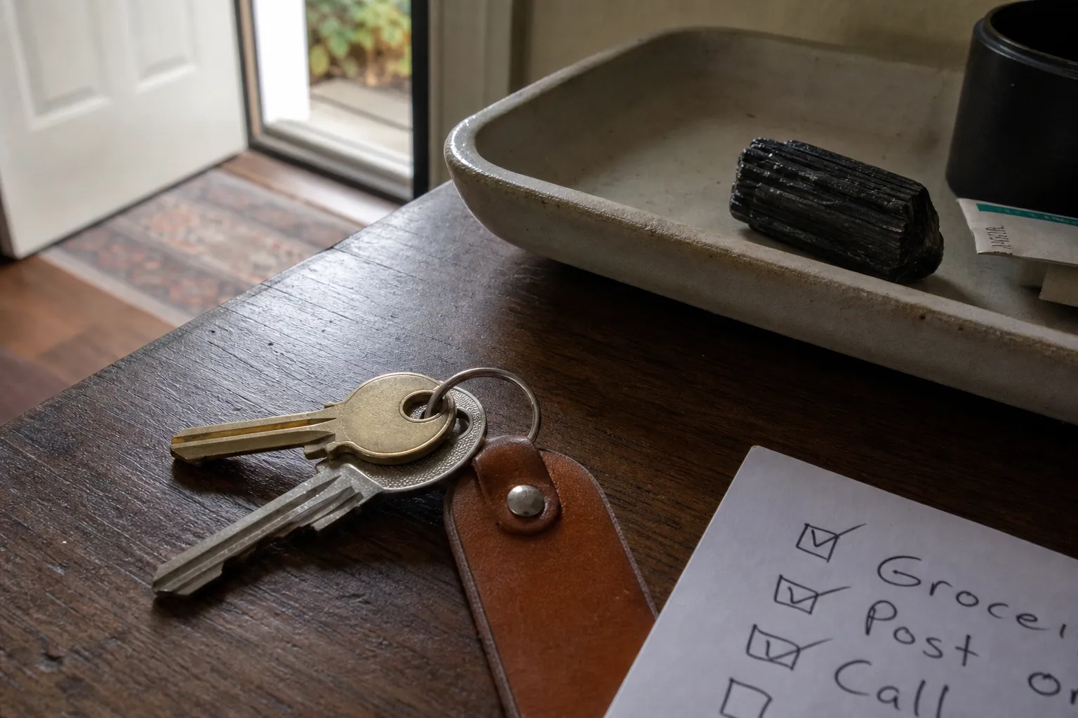 A short crystal-use note beside keys and a black tourmaline specimen left at home
