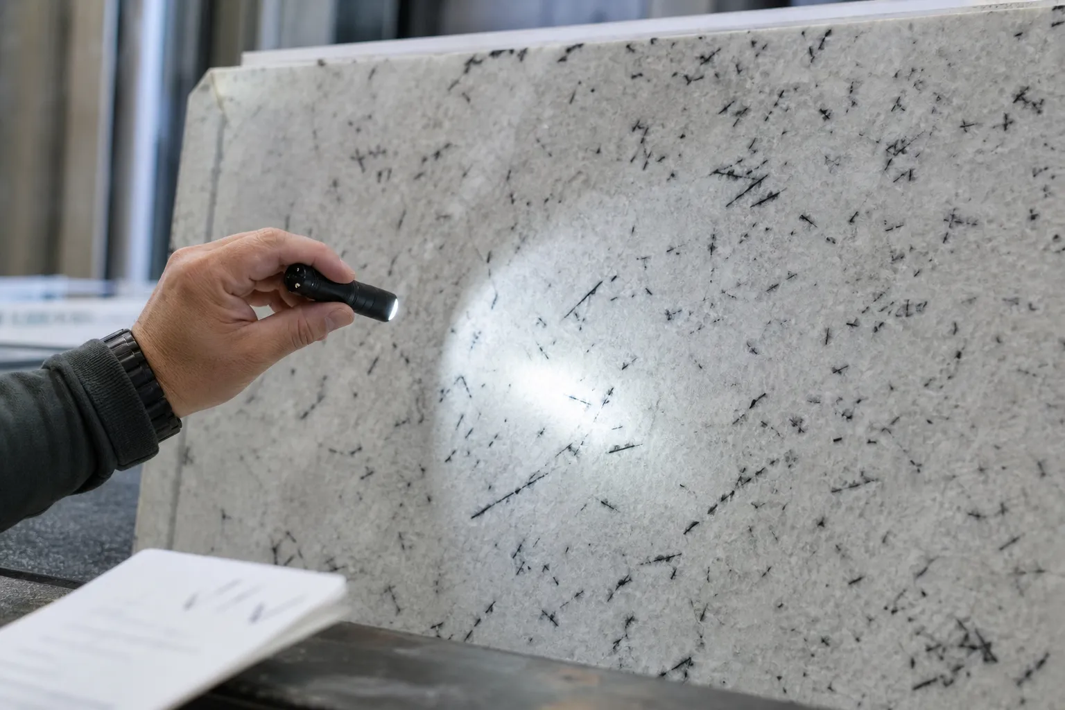 Close inspection of a tourmalinated quartz slab showing inclusion density, line direction, background color, and finish under realistic light